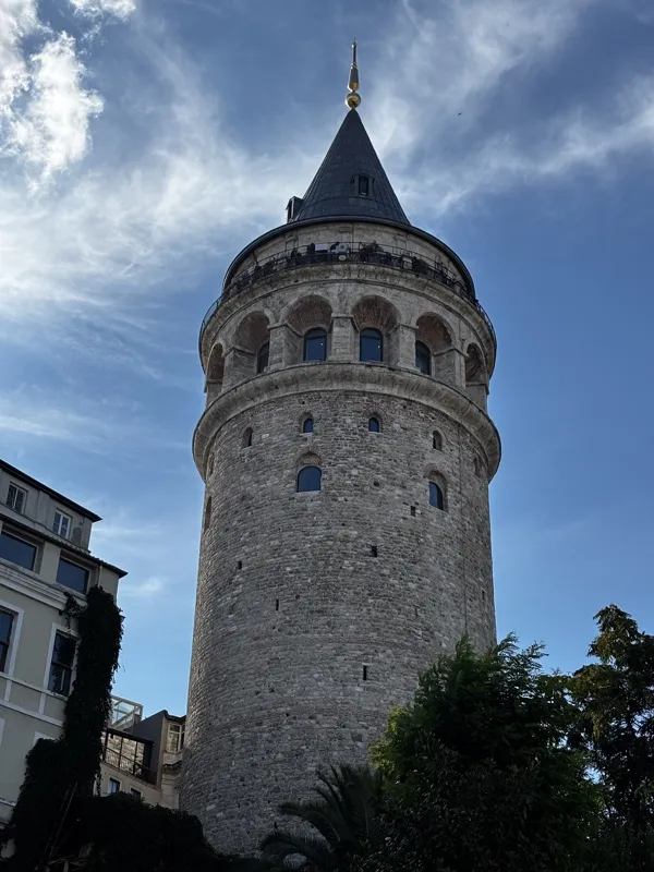 Galata Tower against a blue sky with light clouds