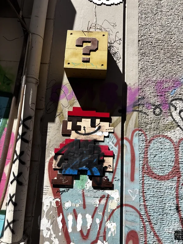 Pixel-art Mario and a question block on a graffiti-covered wall